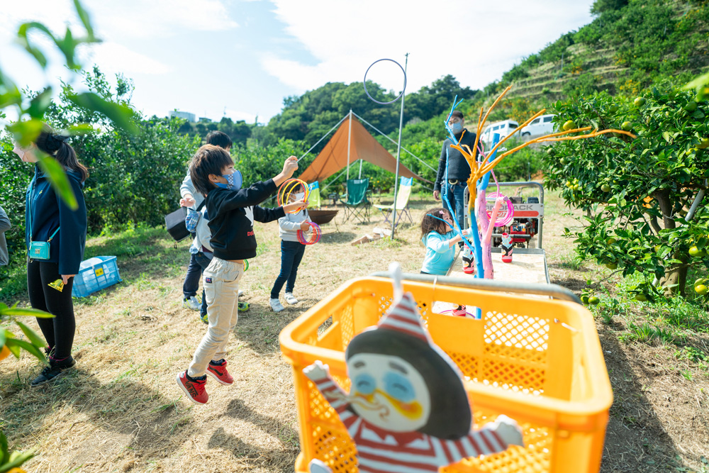 みかん畑で輪投げを楽しむ子どもたち